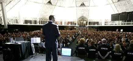 Chris Howard on stage in Sydney, shot from behind, facing a domed arena crowd