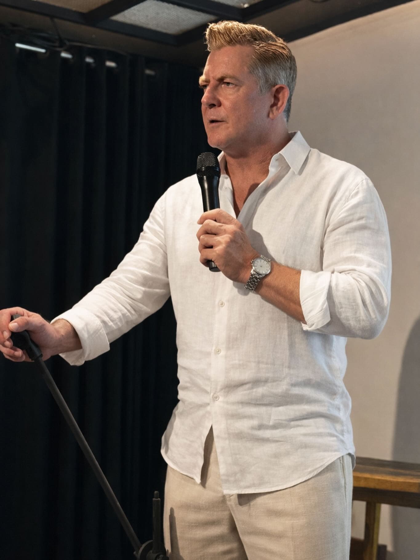 Chris Howard speaking to a room, microphone in hand
